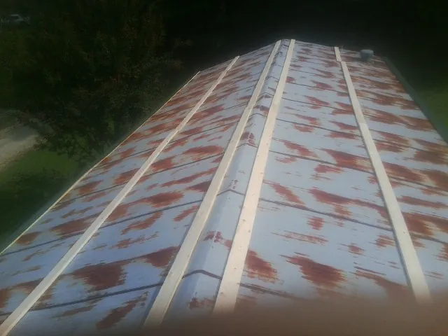 Rusted metal roof panels with new wood purlins before replacement — Storm Damage Roof Repair in Mount Saint Joseph by Roofing Brothers