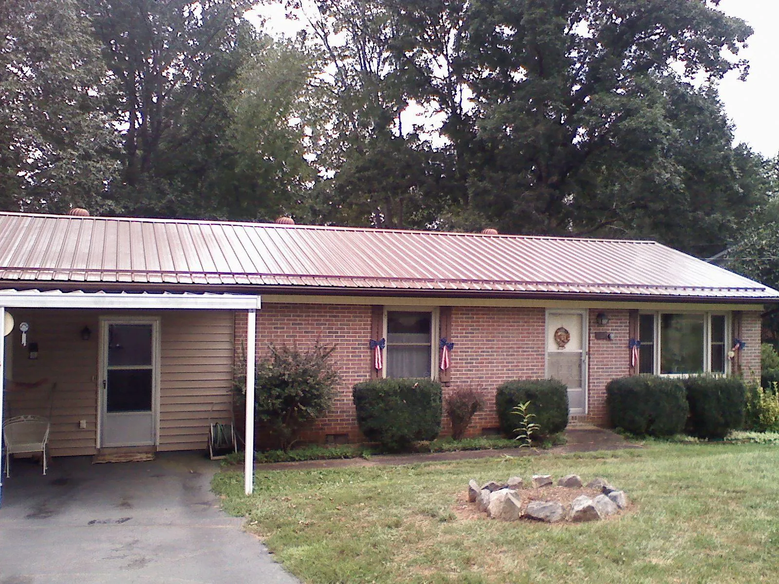 Bronze metal roof and carport on a brick ranch home — Roof Repair work by our crew in Mount Saint Joseph